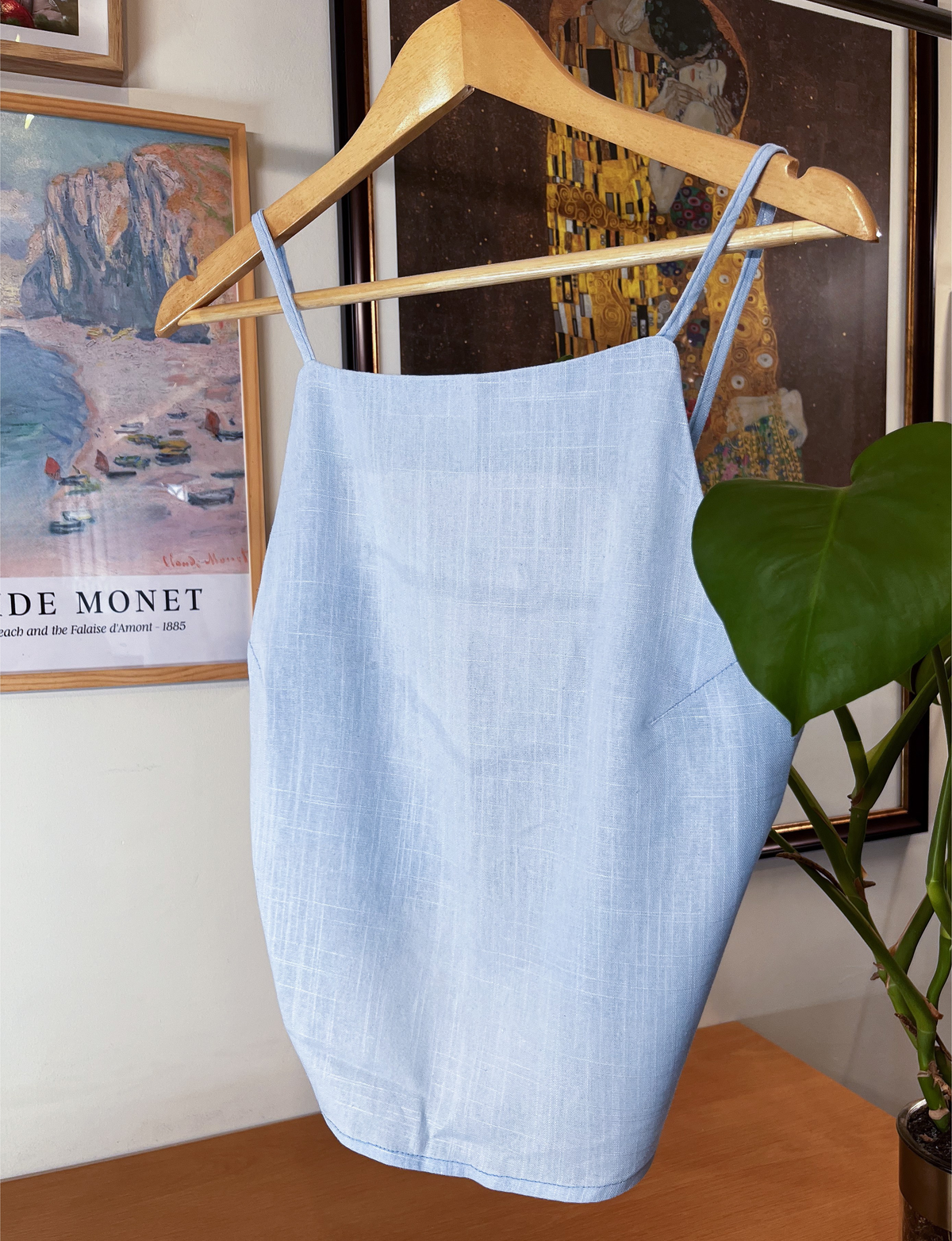 Bare-Back Beauty light blue linen top on a hanger, showing adjustable straps