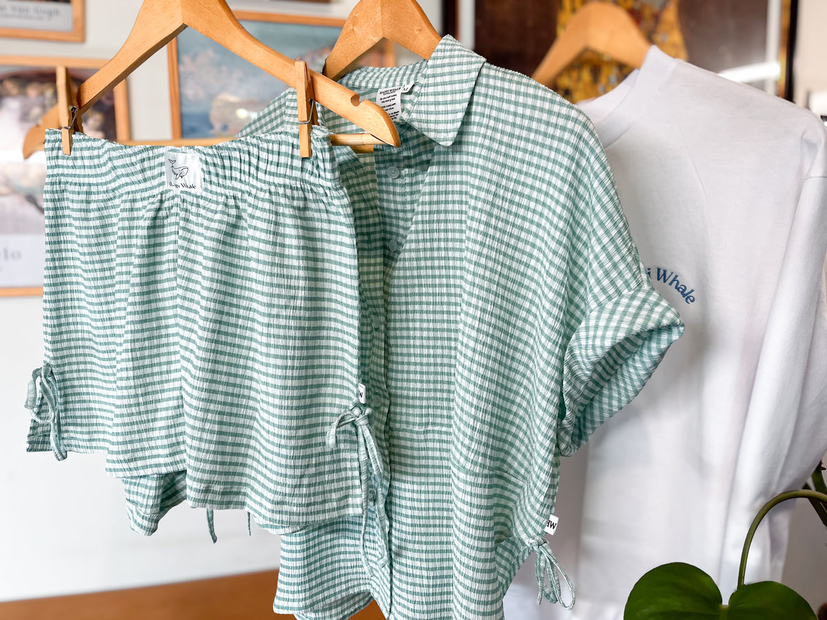 Cloud PJ shirt and shorts hanging on wooden hangers beside a white crew