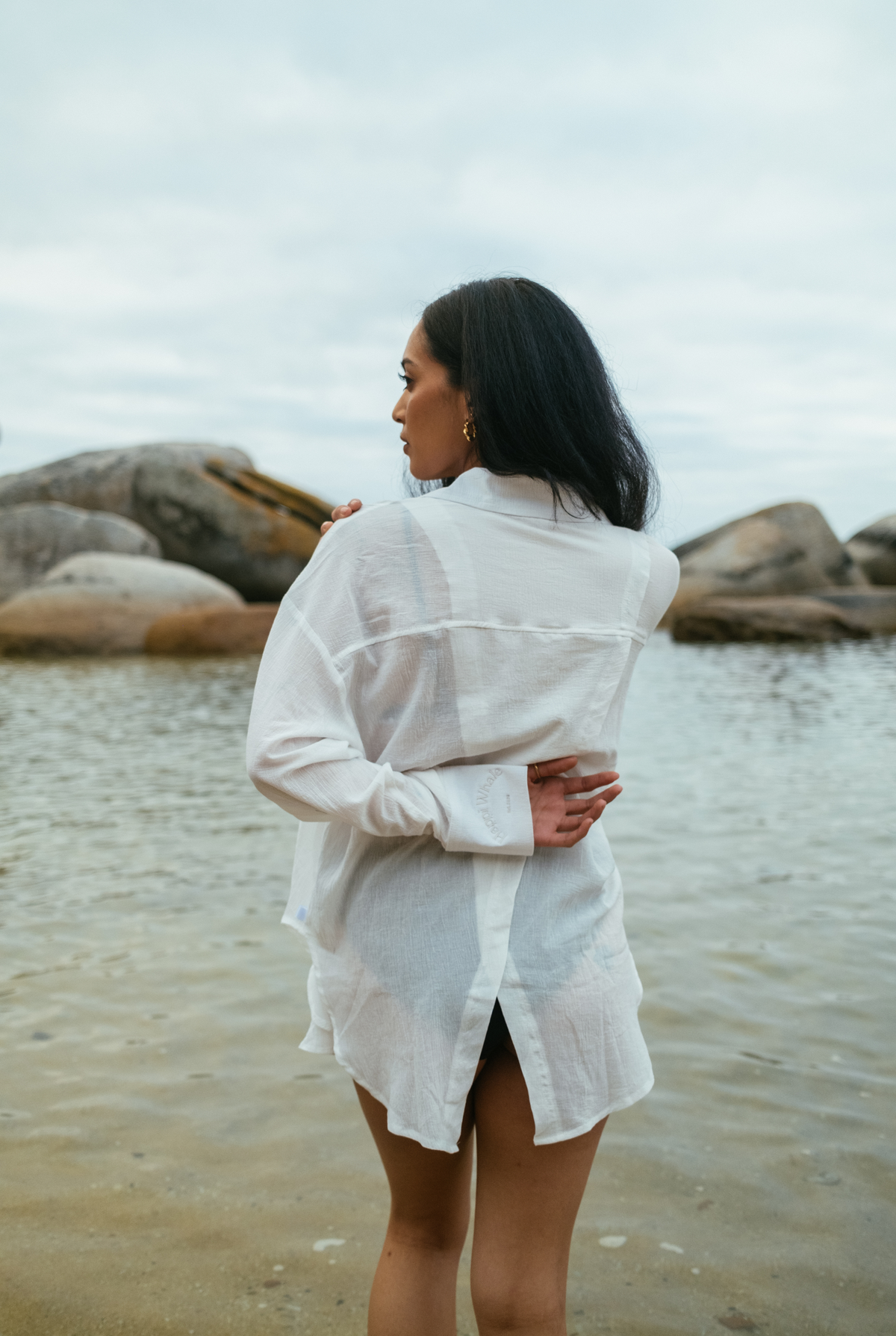 Back view of the oversized white Hillie's Breeze Shirt worn at the water's edge
